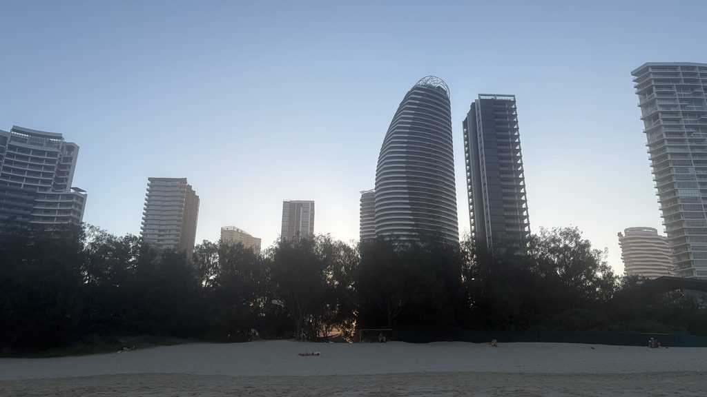 Broadbeach beachfront at twilight with the high-rise skyline behind the dune